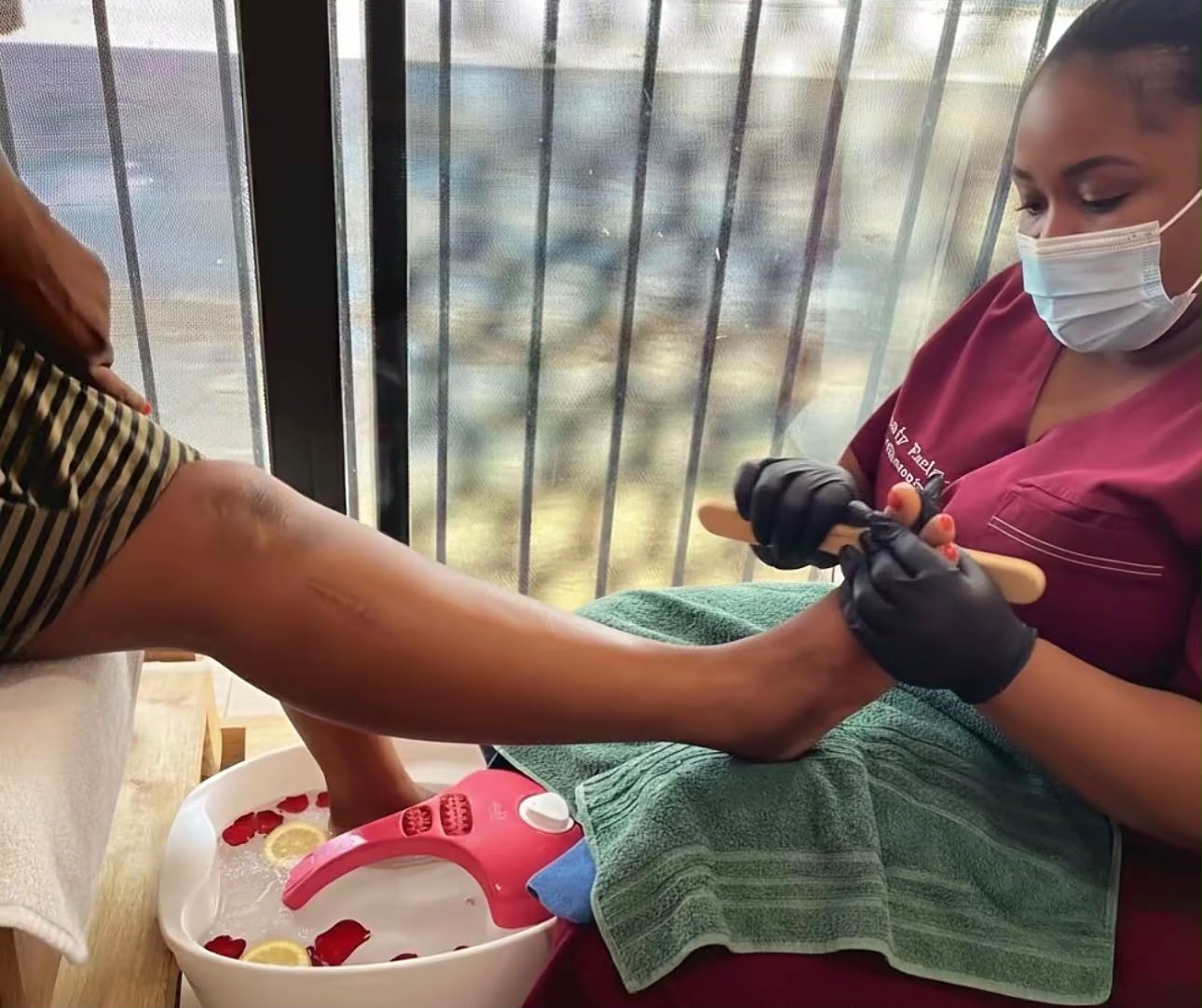 Therapist filing a client's toe nails during a deluxe pedicure