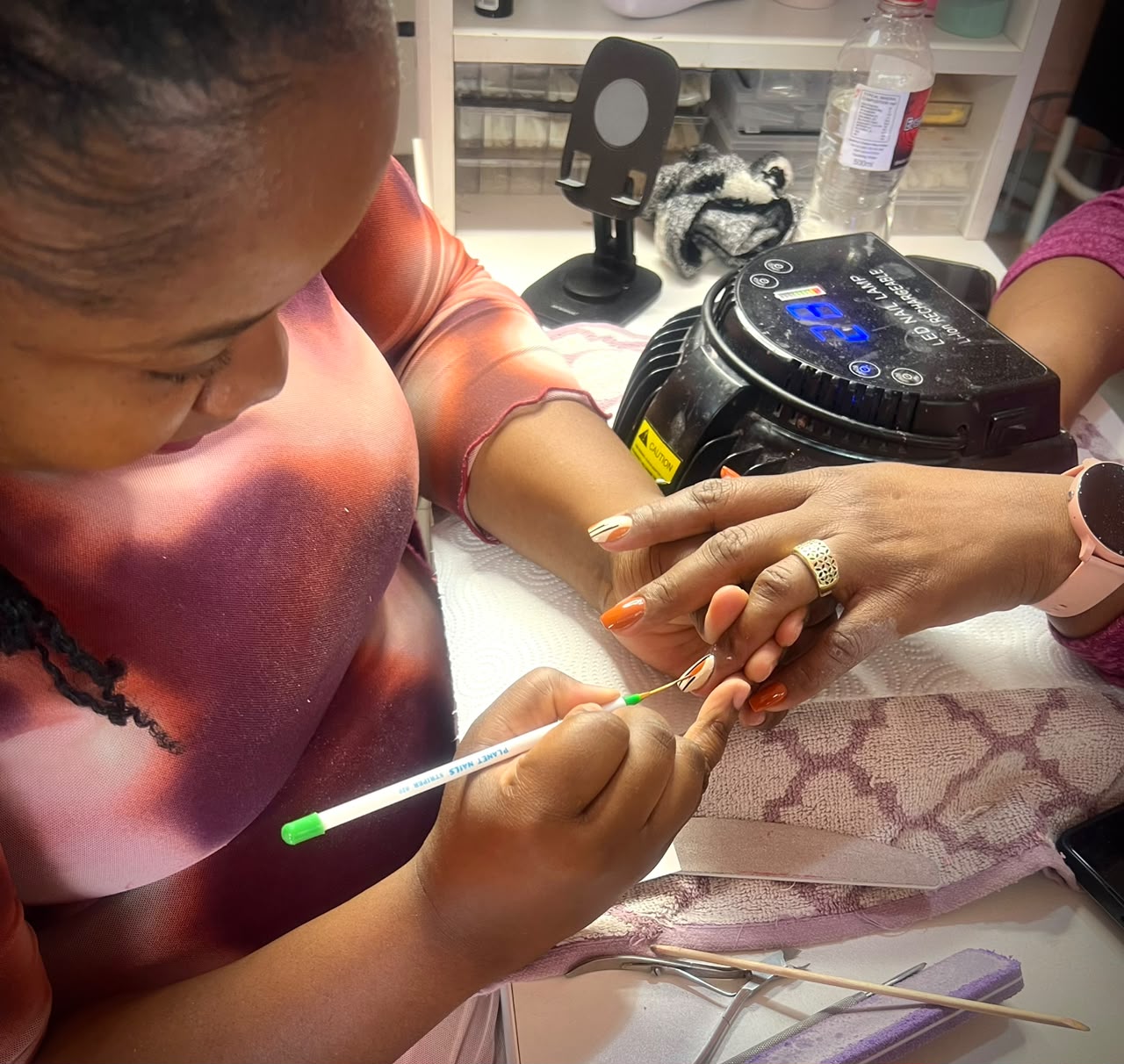 Nail technician painting a client's nails at PEY Beauty Parlour