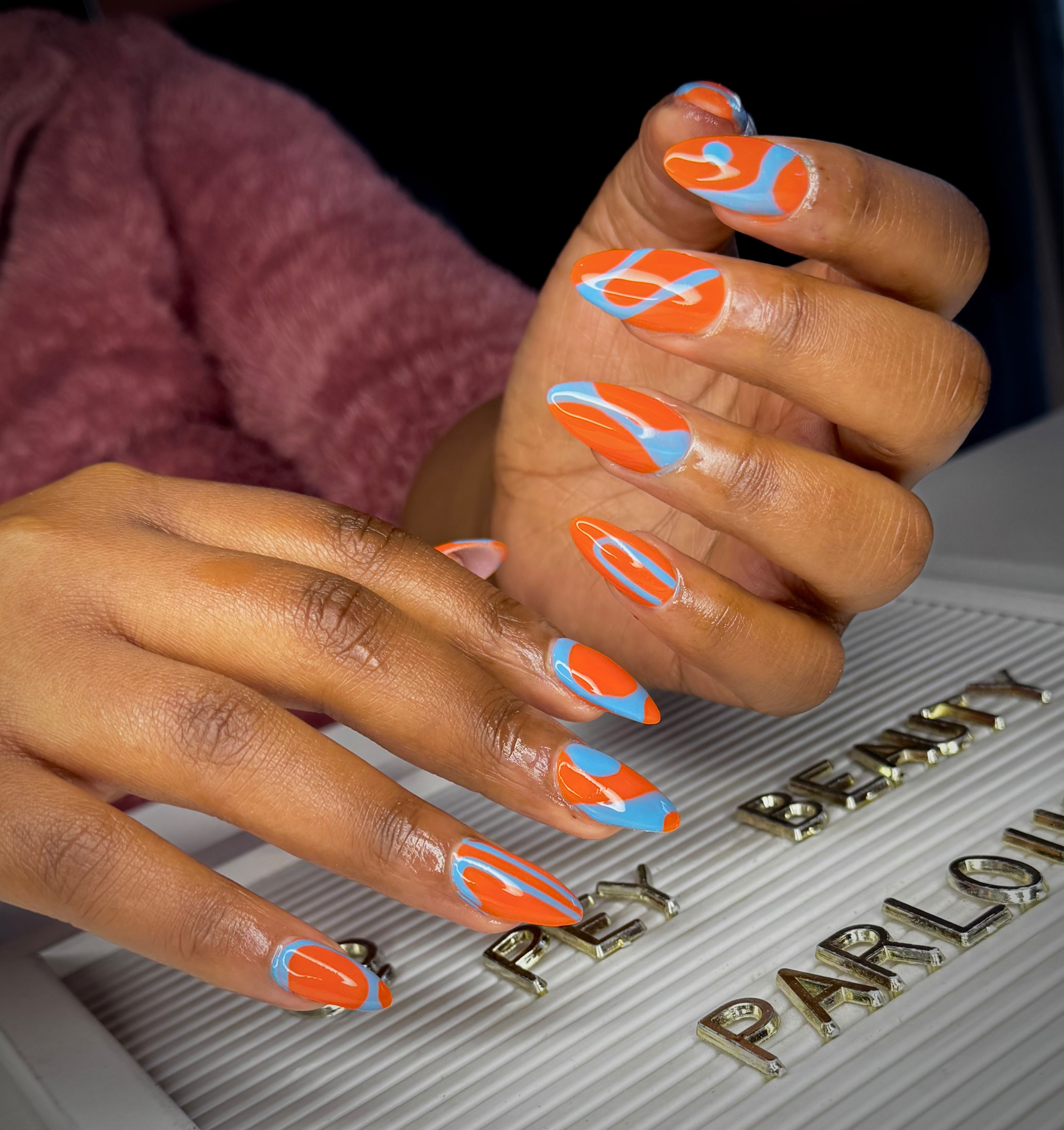 Orange and blue swirl nail art
